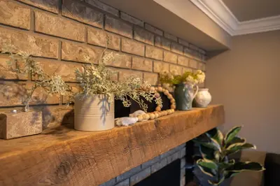 a brick wall with three vases on a shelf at By the Sea in Campbell River