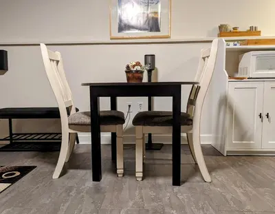 a dining room table with two chairs and a table at By the Sea in Campbell River