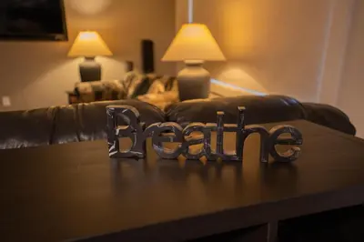 a wooden table with the word racism in front of a couch at By the Sea in Campbell River