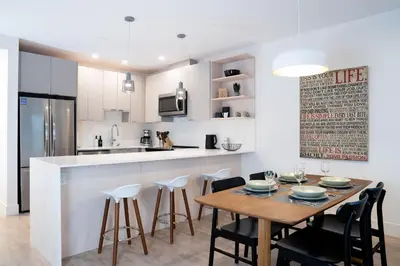 a kitchen and dining room with a wooden table and chairs at Summit Views Condo by Revelstoke Vacations in Revelstoke