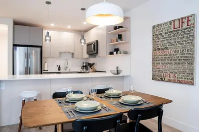 a kitchen and dining room with a wooden table and chairs at Summit Views Condo by Revelstoke Vacations in Revelstoke