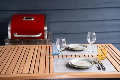 a wooden table with two wine glasses and plates on it at Summit Views Condo by Revelstoke Vacations in Revelstoke