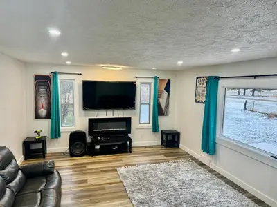 a living room with a couch and a flat screen tv at Farmstay in Edmonton in Duffield
