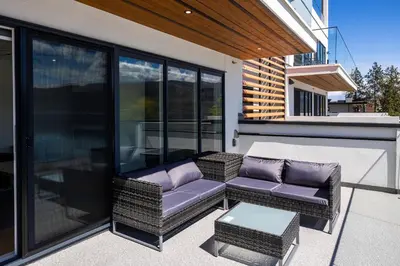 a patio with two chairs and a couch and a table at Premium Deluxe PeachView Suites 3BR in Peachland