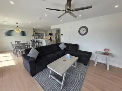 a living room with a black couch and a table at Premium Deluxe PeachView Suites 3BR in Peachland