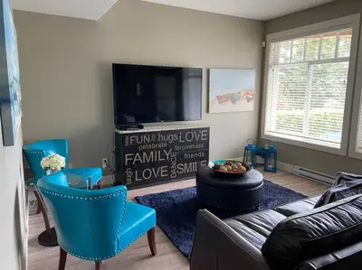 a living room with a couch and a flat screen tv at White Rock Beach getaway in White Rock