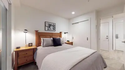 a bedroom with a large bed and a wooden dresser at Bear Lodge, Whistler Village - Spectacular Location on Village Stroll, Designer Remodel in Whistler