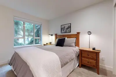 a bedroom with a large bed and a window at Bear Lodge, Whistler Village - Spectacular Location on Village Stroll, Designer Remodel in Whistler