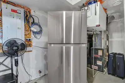 a kitchen with a refrigerator and a fan at ModernSuite*NearAirport*2Queens*2Bedroom*FullKitchen in Edmonton
