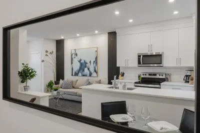a kitchen and living room with a large mirror at Townhome with Free Parking, Near Downtown in Calgary