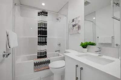 a white bathroom with a toilet and a sink at Townhome with Free Parking, Near Downtown in Calgary