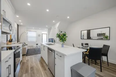 a kitchen with white counters and a table and chairs at Townhome with Free Parking, Near Downtown in Calgary