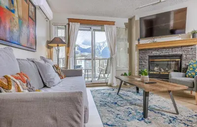 a living room with a couch and a fireplace at Lovely Mountain View 2 Bedroom Suite in Canmore