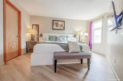 a bedroom with a white bed and a chair at Lovely Mountain View 2 Bedroom Suite in Canmore