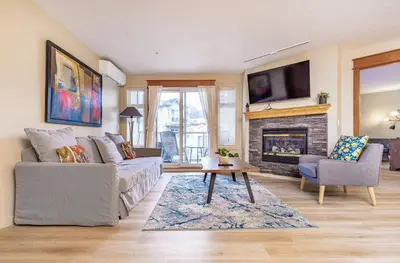a living room with a couch and a fireplace at Lovely Mountain View 2 Bedroom Suite in Canmore