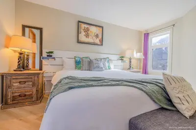 a bedroom with a large white bed and a window at Lovely Mountain View 2 Bedroom Suite in Canmore