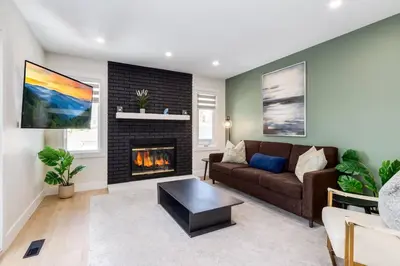 a living room with a couch and a fireplace at Pet Friendly & Accessible, 4 Beds in Calgary