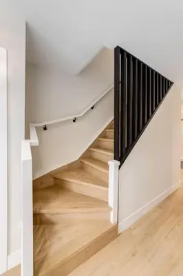 a staircase in a house with white walls and wooden floors at Pet Friendly & Accessible, 4 Beds in Calgary