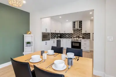 a kitchen and dining room with a wooden table and chairs at Pet Friendly & Accessible, 4 Beds in Calgary
