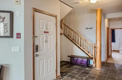 a hallway with a staircase and a white door at Snowy Creek by Okanagan Premier in Big White