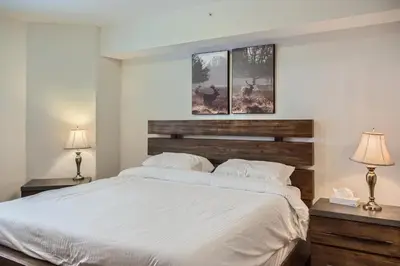 a bedroom with a large white bed with two lamps at Snowy Creek by Okanagan Premier in Big White