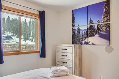 a bedroom with a window and a bed and a dresser at Snowy Creek by Okanagan Premier in Big White
