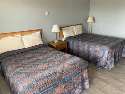 a hotel room with two beds and two lamps at Wild Rose Inn in Vegreville