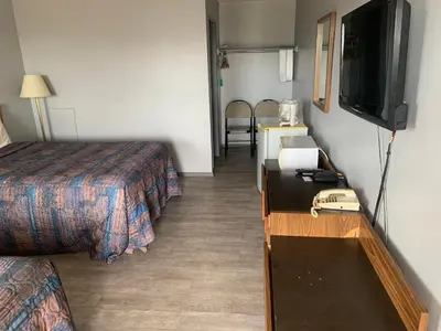 a hotel room with two beds and a television at Wild Rose Inn in Vegreville