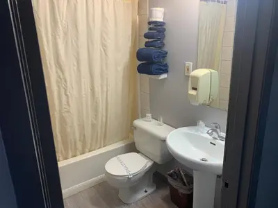 a bathroom with a toilet and a sink at Wild Rose Inn in Vegreville