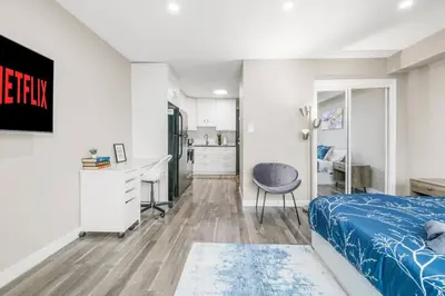 a bedroom with a bed and a desk and a chair at Modern & Unique Studio Unit in Edmonton