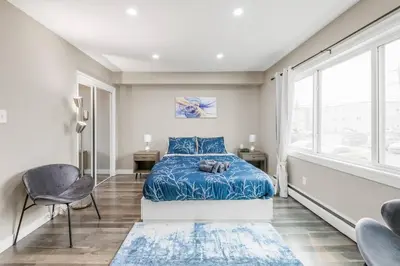 a bedroom with a bed and a large window at Modern & Unique Studio Unit in Edmonton