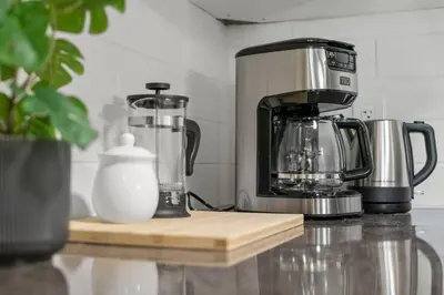 a kitchen counter with a coffee maker and a blender at Modern & Unique Studio Unit in Edmonton