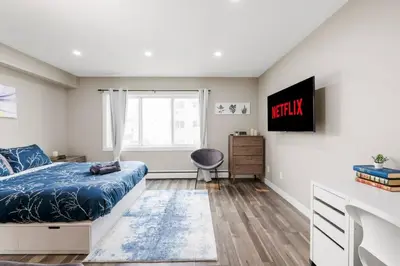 a bedroom with a bed and a desk and a window at Modern & Unique Studio Unit in Edmonton