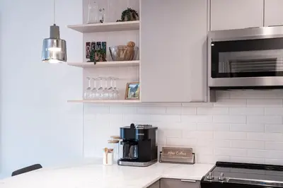 a white kitchen with a coffee maker on a counter at Tucker's Place in Revelstoke