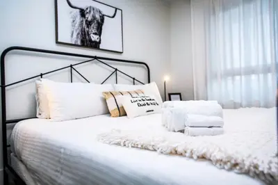 a bedroom with a white bed with white pillows at Tucker's Place in Revelstoke