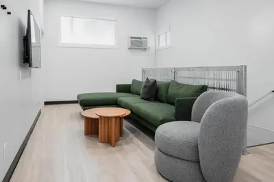 a living room with a green couch and a table at Gravity Haus Revelstoke in Revelstoke