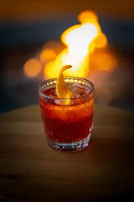 a drink with a lemon peel in a glass at Gravity Haus Revelstoke in Revelstoke