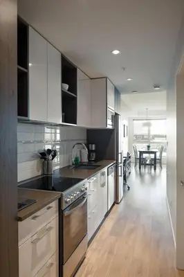 a kitchen with white cabinets and a dining room at Be The Perfect Cityzen In Cityzen in Victoria