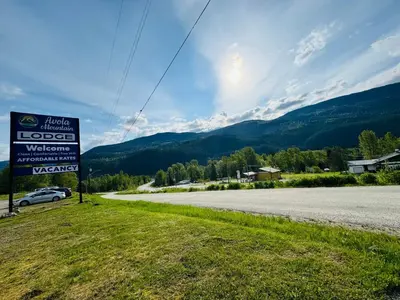a sign on the side of a road at Avola Mountain Lodge in Avola