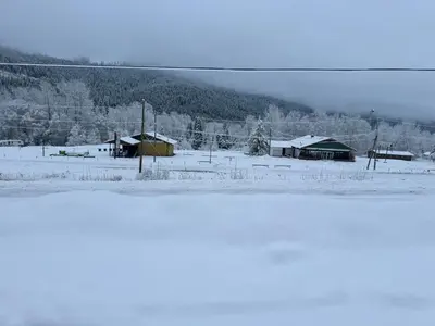 a snow covered field with houses and buildings at Avola Mountain Lodge in Avola