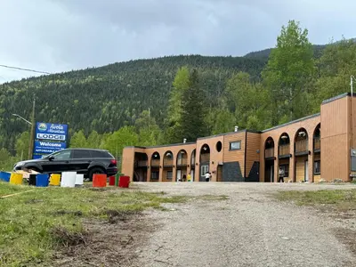 a car is parked in front of a building at Avola Mountain Lodge in Avola