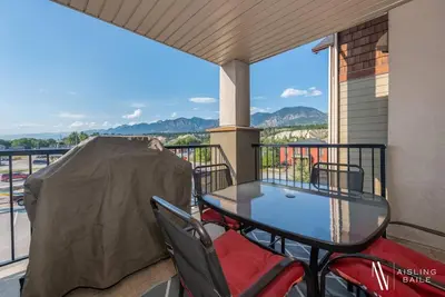 a table and chairs on a balcony with a view at Contemporary, Cozy, Pool, Hot Tub, Lake Front in Invermere