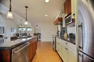 a large kitchen with wooden cabinets and a large counter top at Magnificent Mountain Penthouse - Hot Tub & Pool managed by Little Sister Getaways in Canmore