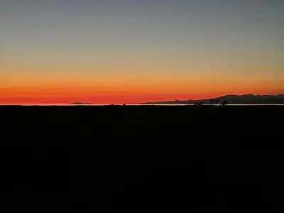 a sunset in the desert with mountains in the background at Home In Vancouver in Richmond