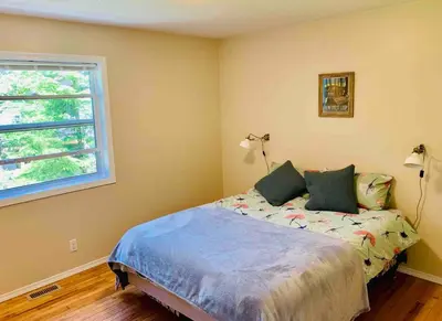 a bedroom with a bed and a window at Blue Cedar Suite in Tofino