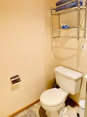 a bathroom with a white toilet and a towel rack at Blue Cedar Suite in Tofino
