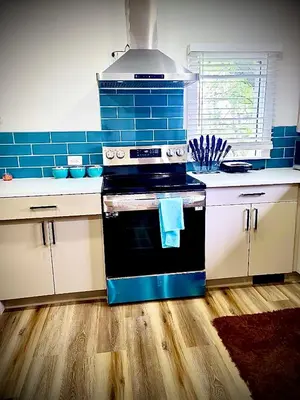 a kitchen with a black stove and blue tile at Farmhouse in Alberta in Duffield