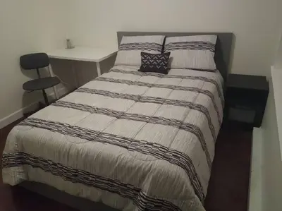 a bed in a room with a desk and a bed sidx sidx sidx at Marine Drive Station Entire House in Vancouver