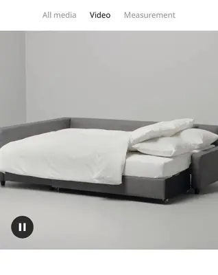 a bed with a black frame and white sheets and pillows at Marine Drive Station Entire House in Vancouver