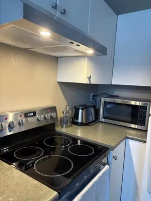 a kitchen with a stove top oven next to a microwave at Marine Drive Station Entire House in Vancouver